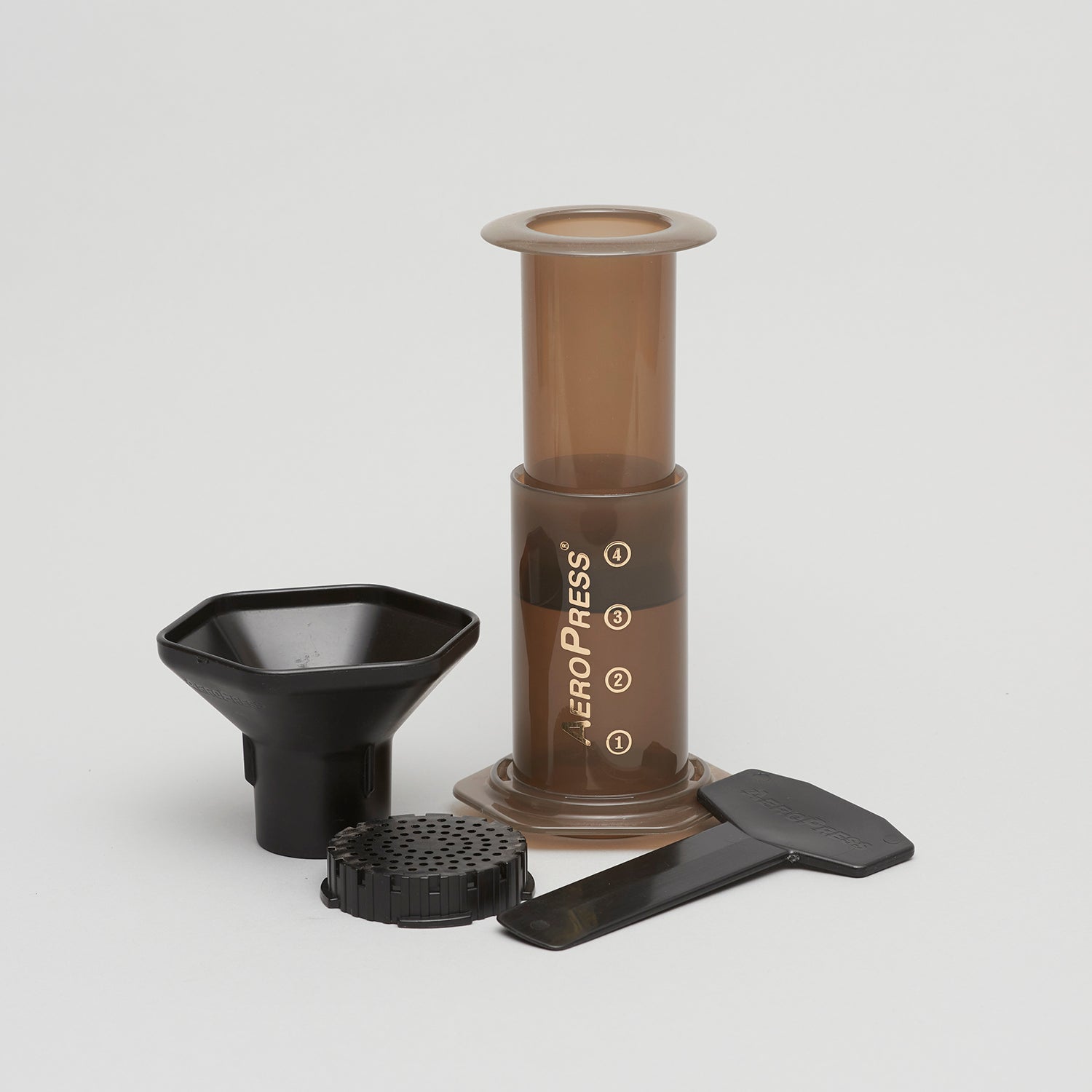 Image shows the Aeropress Coffee Maker, including the mixer chamber, filter cap, plunger, filter holder, finnel and stir stick.