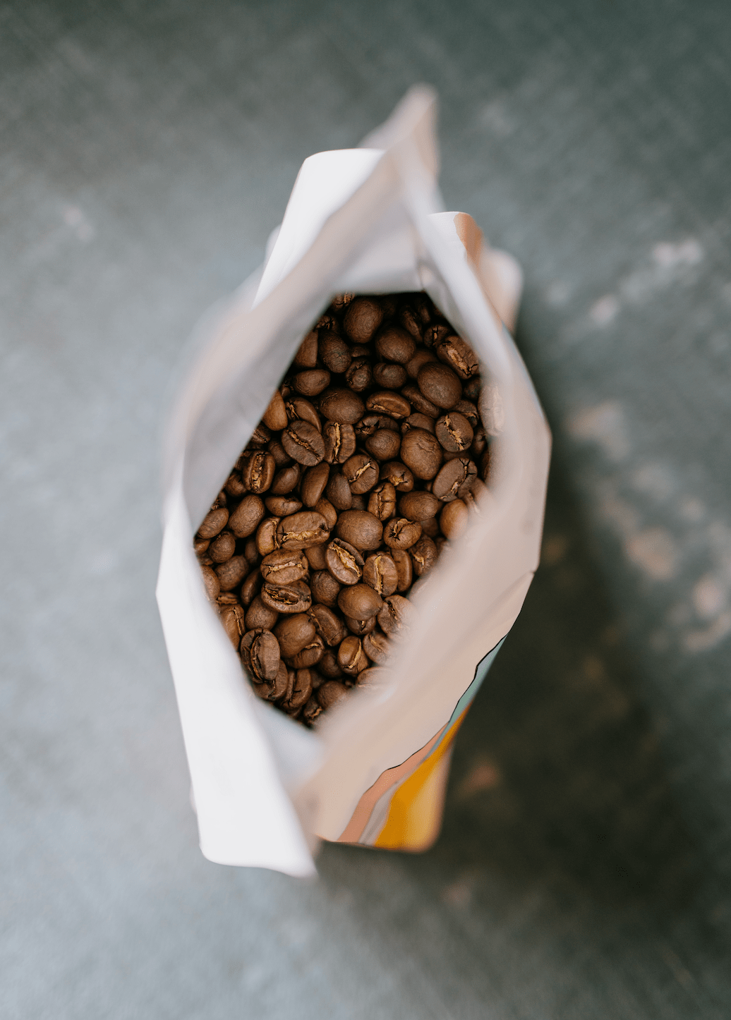 A bag of roasted coffee beans from Missing Bean Coffee Roasters, sitting on a table, ready to be brewed.