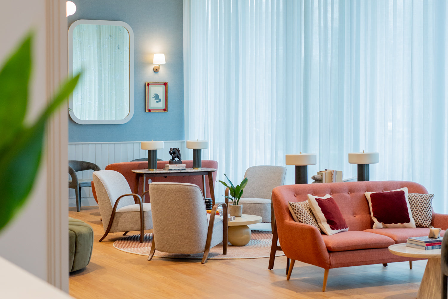 The interior of Missing Bean Cowley, featuring mid century furniture, blue curtains and a red sofa.
