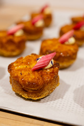 Missing Bean's Rhubarb & Custard Kouign Amanns with on a silver tray with baking paper.