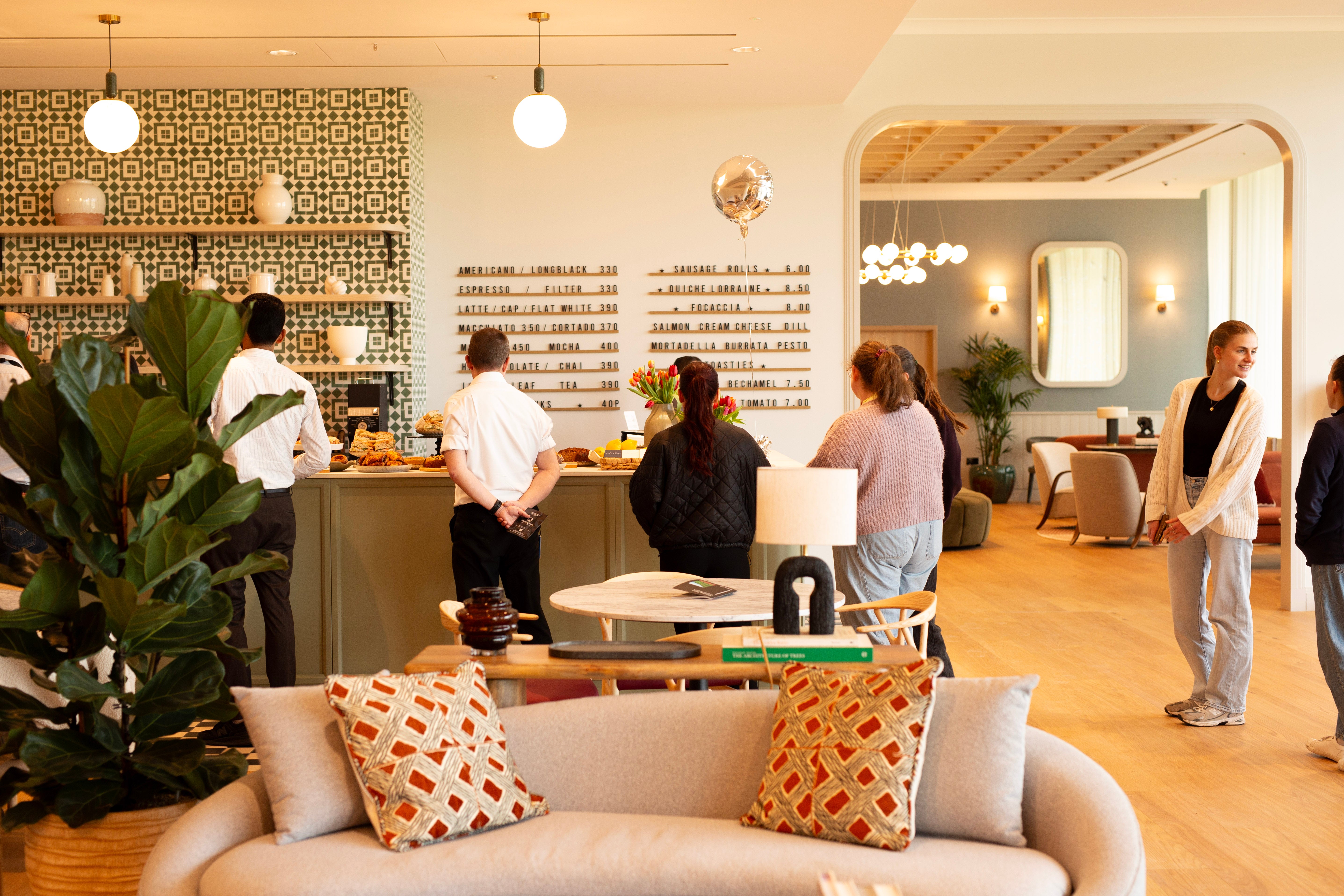Missing Bean Cowley interior with a queue of people, plants, and decor.