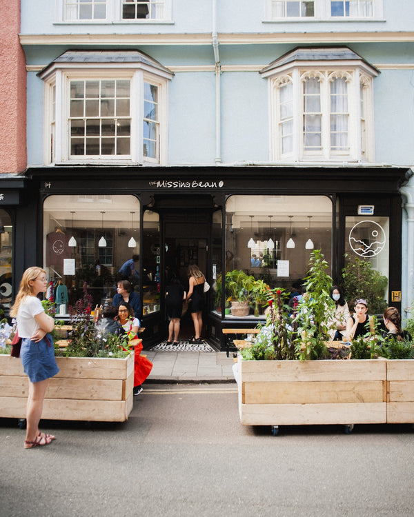 The exterior of the Missing Bean cafe on Turl Street in Oxford. Customers enjoying their coffee in the outside seating area.