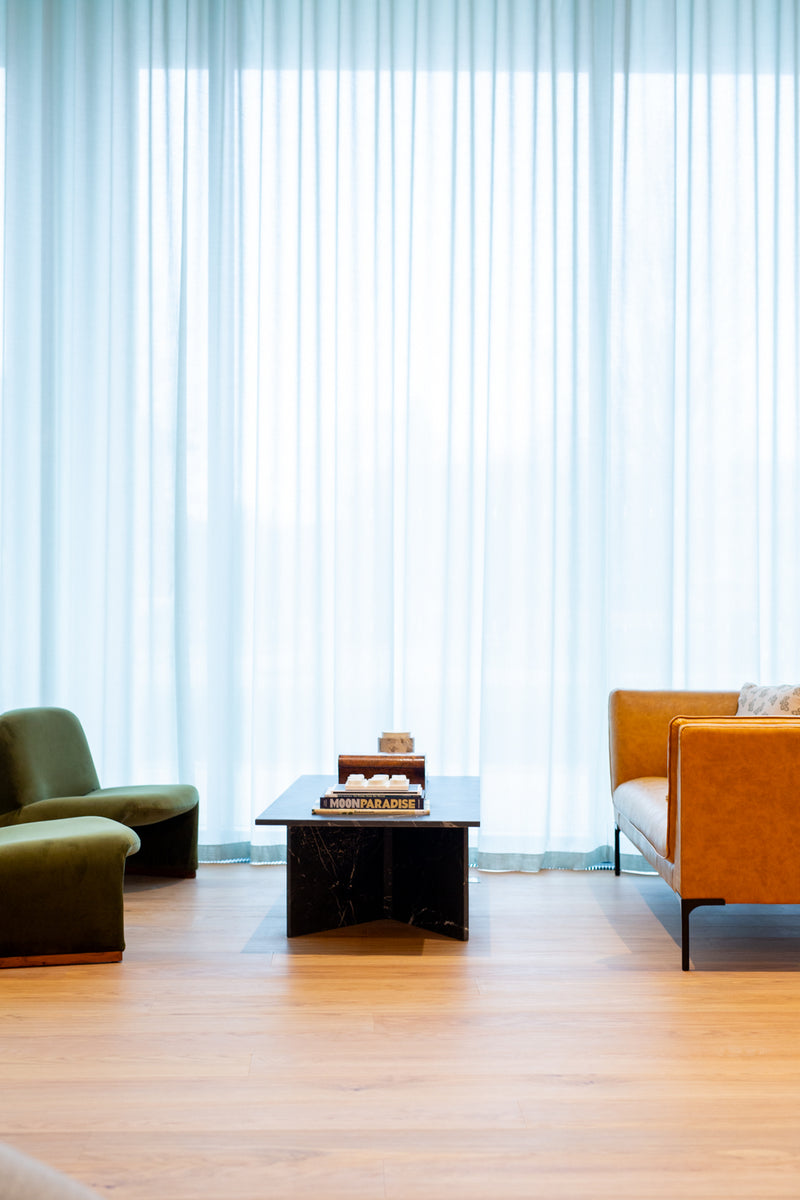 Interior of Missing bean's Cowley café with green and orange chairs and a coffee table in front of large windows.