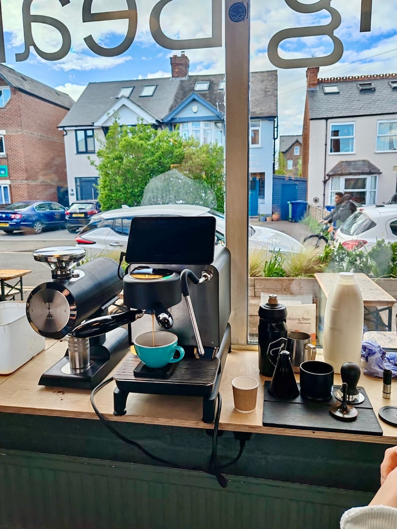 Decent Espresso equipment Missing Bean's Roastery window table with a view of a street outside.